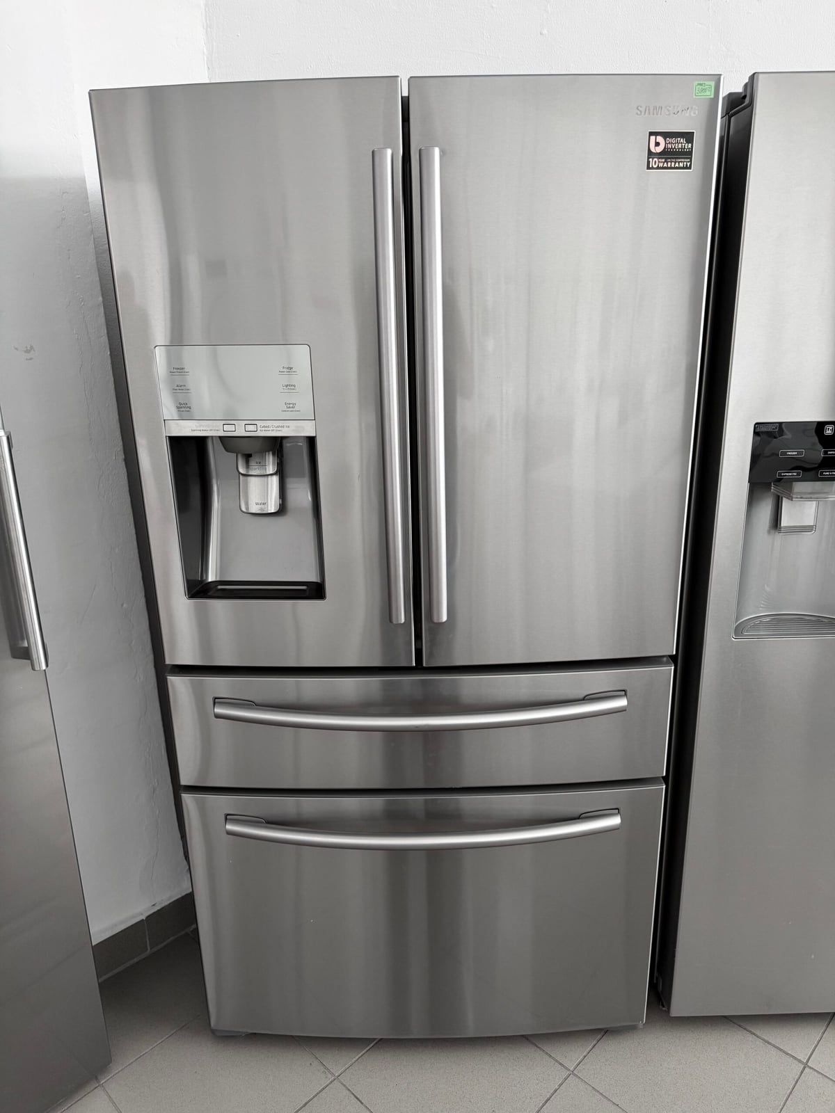 Frigider side-by-side din inox, cu dozator de apă și gheață, într-o bucătărie